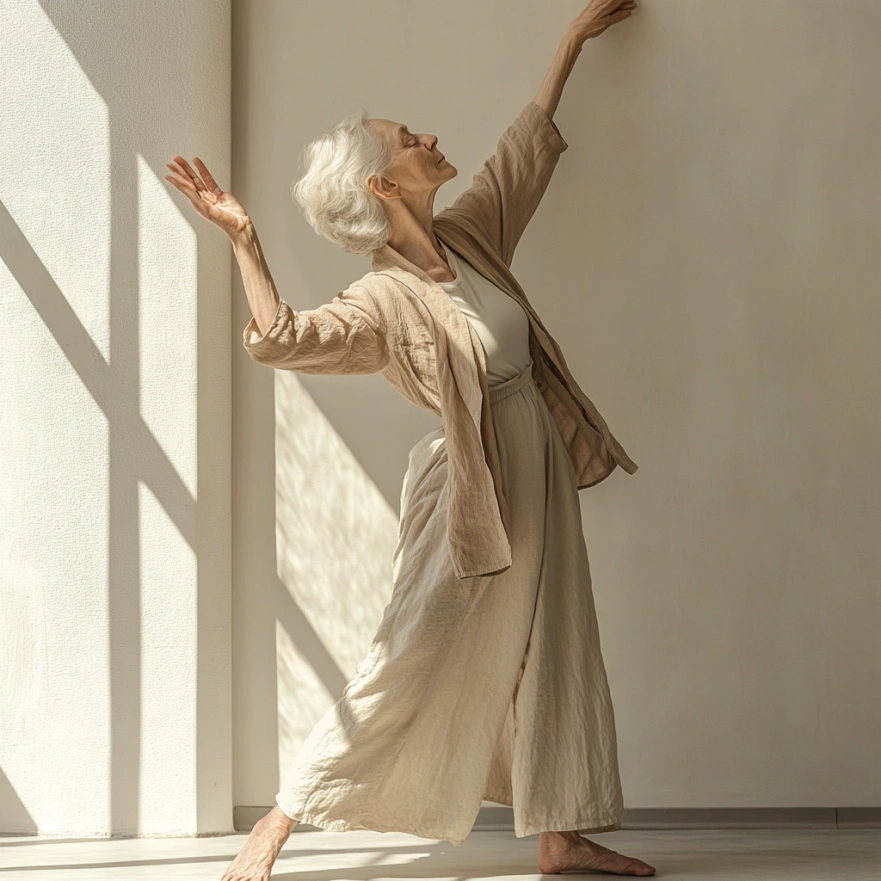 Жінка похилого віку виконує м'яку розтяжку стоячи біля стіни для підтримки балансу в світлому залі